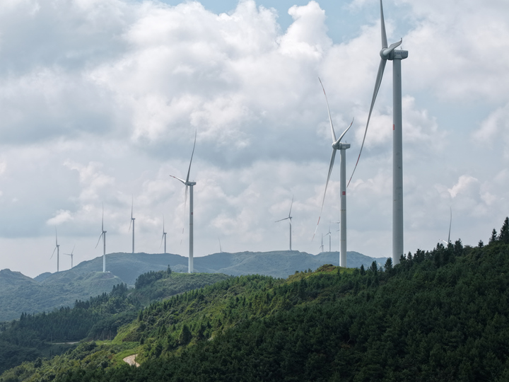 風機屹立山頂隨風而轉。