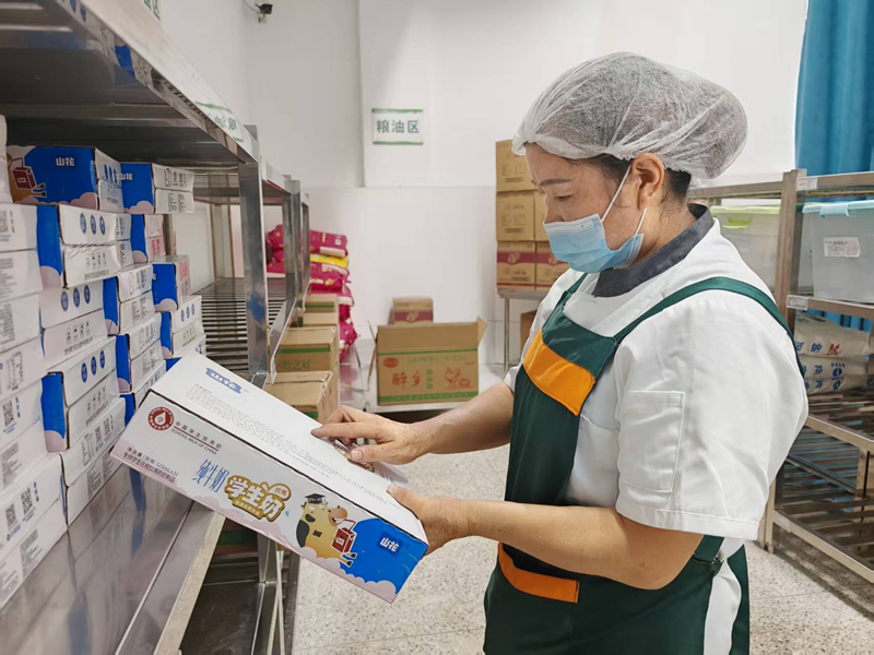 2、工作人員仔細(xì)查驗(yàn)“學(xué)生奶”,確保食材安全。謝永恒 攝.jpg