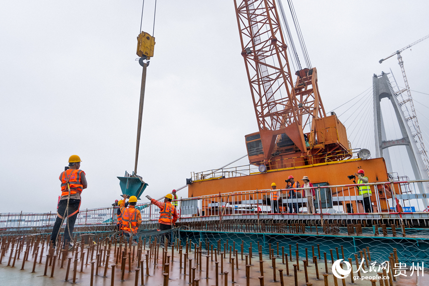 建設者正在吊裝大橋的最后一片小縱梁。人民網記者 涂敏攝