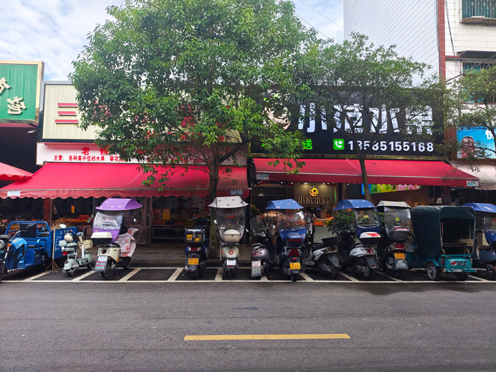 貴定縣荷花綜合市場門口整齊擺放的電動車。