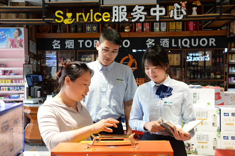 郵儲銀行工作人員走訪卷煙商戶獲取其資金需求。郵儲銀行貴州省分行供圖