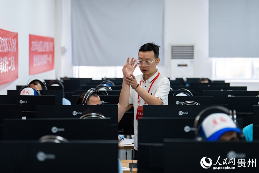 工作人員協助視障考生完成綜合筆試。人民網記者 涂敏攝