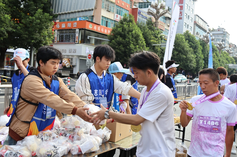 志愿者為完賽運(yùn)動(dòng)員發(fā)放補(bǔ)給包。王永勝攝