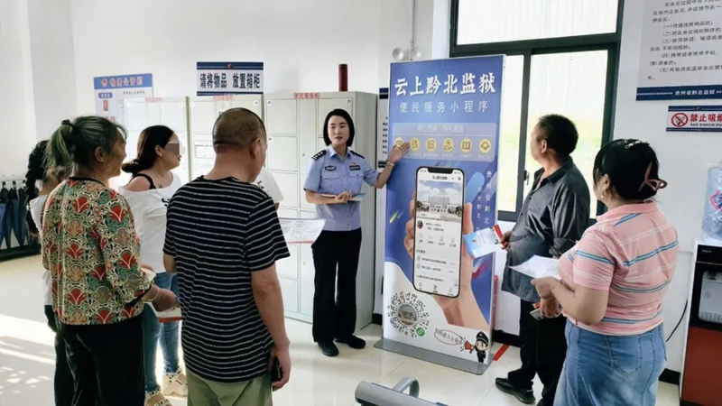 民警在為罪犯家屬講解“云上黔北監獄”小程序使用方法。
