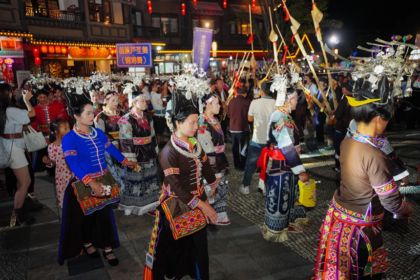 9月16日，在貴州省丹寨縣萬達小鎮，身著傳統服飾的苗族群眾與游客在跳蘆笙舞。