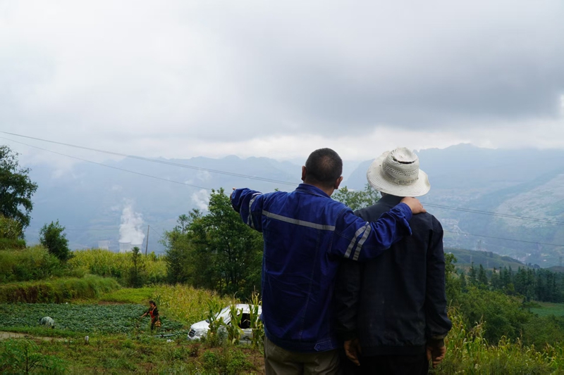 陳彥秋(左)給村民介紹納雍電廠。