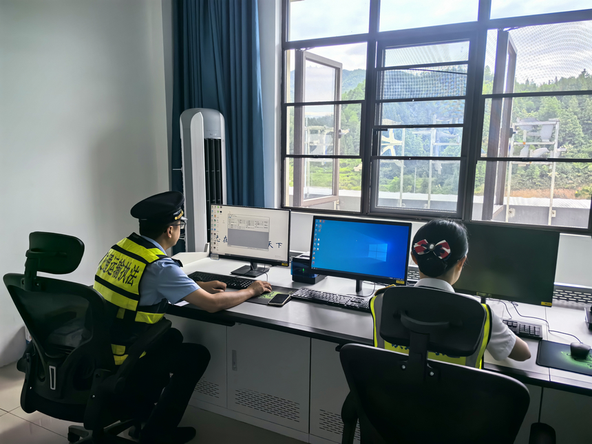 貴州省交通運輸綜合行政執法人員在收費站查看車輛數據進行排查。