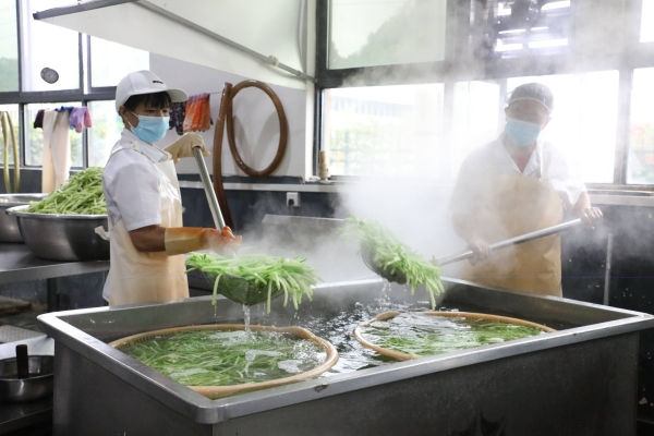 工人在給佛手瓜焯水。