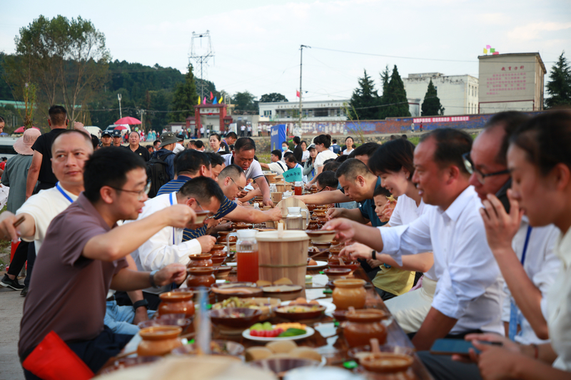 七星關區2025年中國農民豐收節分會場活動現場, 稻田長桌宴 游客與村民共品菜肴,共話豐收年景。