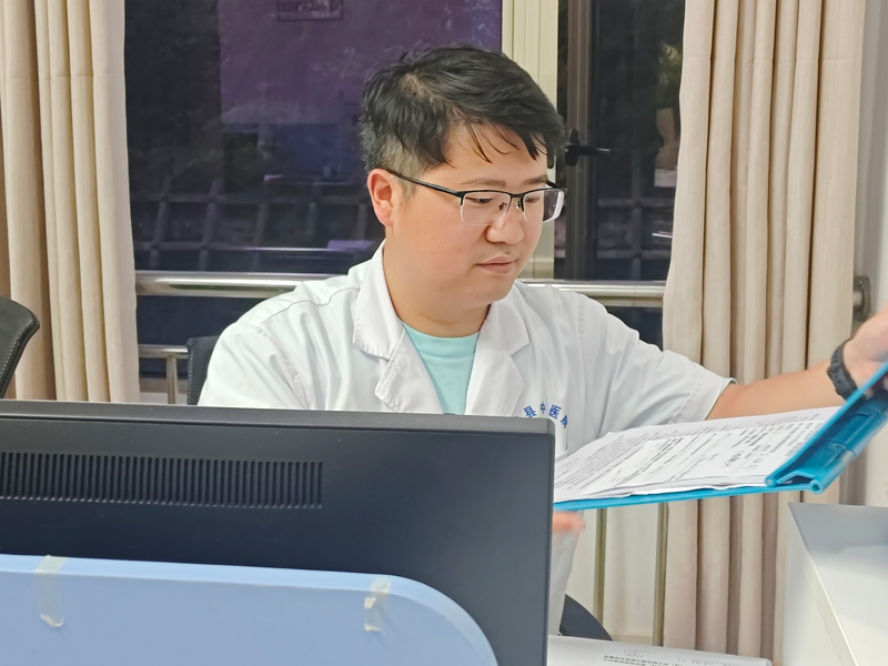 桐梓縣中醫醫院值班醫生正在查看患者病歷 陳娟攝.jpg