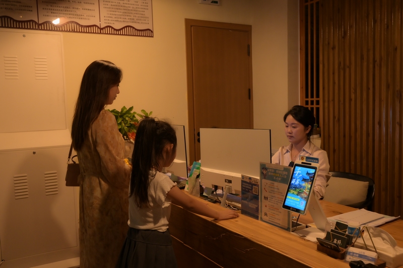 在仁懷市長崗鎮藺田村塵外楠山民宿接待大廳,游客正在辦理入住。