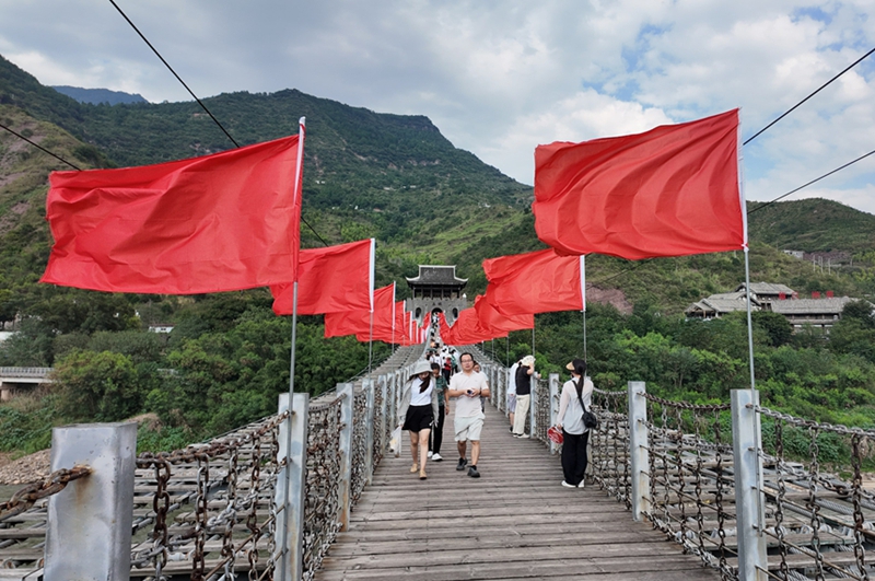 鐵索橋上一排排整齊懸掛的紅旗迎風招展。姚瑤 攝.jpg