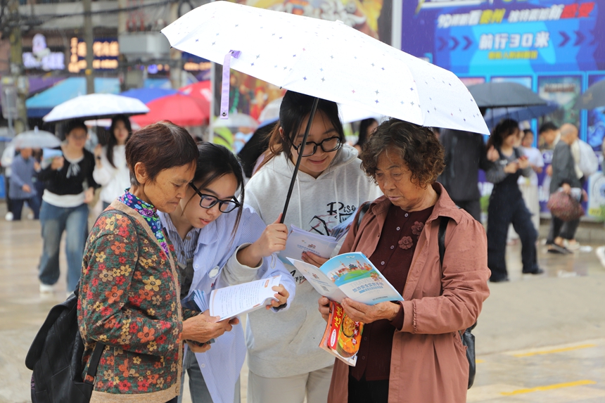 科普現場，學生志愿者正結合《旅游避“坑”指南》，為游客詳細解析常見旅游消費陷阱。