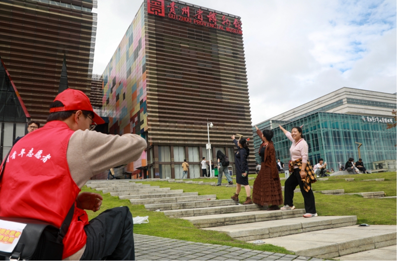 9、在貴州省博物館，觀山湖區青年志愿者為游客們拍照。張婷 攝.jpg