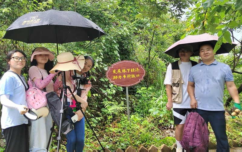 王橙澄帶領學生在鎮遠縣羊場鎮天麻種植園內冒雨采訪貴州省勞模、省農村致富帶頭人、“天麻王子”許乃紅.jpg