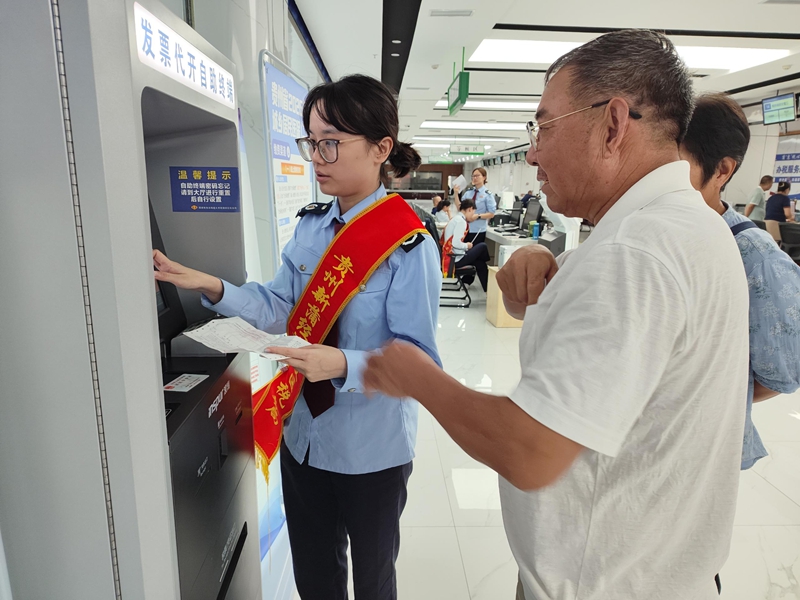 新蒲新區(qū)稅務(wù)局工作人員輔導(dǎo)納稅人自助辦稅設(shè)備操作。 楊小萱供圖.jpg