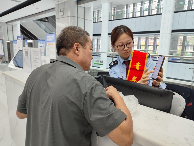 新蒲新區(qū)稅務(wù)局工作人員輔導(dǎo)納稅人“掌上辦”。 楊小萱供圖.jpg