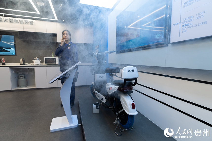 講解員為參觀者演示電動車充電起火燃燒過程。人民網(wǎng)記者 涂敏攝