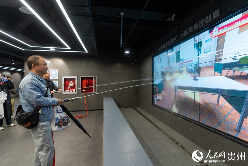 參觀者在科普教育館內(nèi)體驗消防水槍滅火。人民網(wǎng)記者 涂敏攝