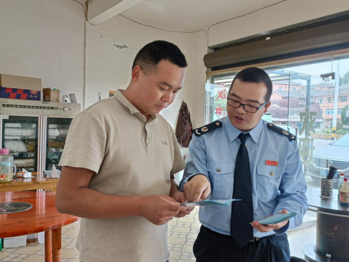 稅務(wù)人員向個體戶經(jīng)營者講解政策。高敏攝