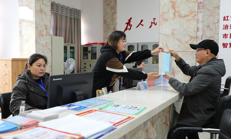 社區(qū)干部為老人提供服務(wù)。