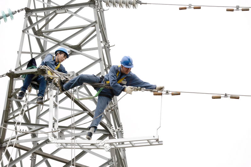 nEO_IMG_南方電網貴州興義供電局輸電管理所綜合數據班高級作業員龍福剛帶領徒弟應用自己研發的安全工具器在110千伏高壓輸電線路上開展檢修工作。盧關文攝