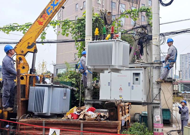 工作人員正在吊裝變壓器。王進(jìn)攝
