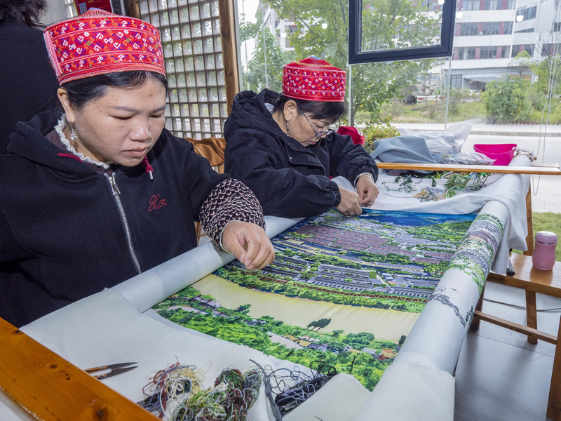 繡娘正在繡制客戶定制的苗繡壁畫。余軍攝