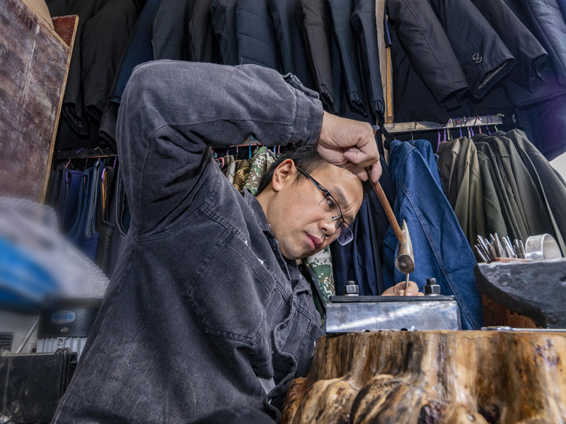 貴州苗韻銀飾有限公司創始人在鍛打純銀手鐲。余軍攝