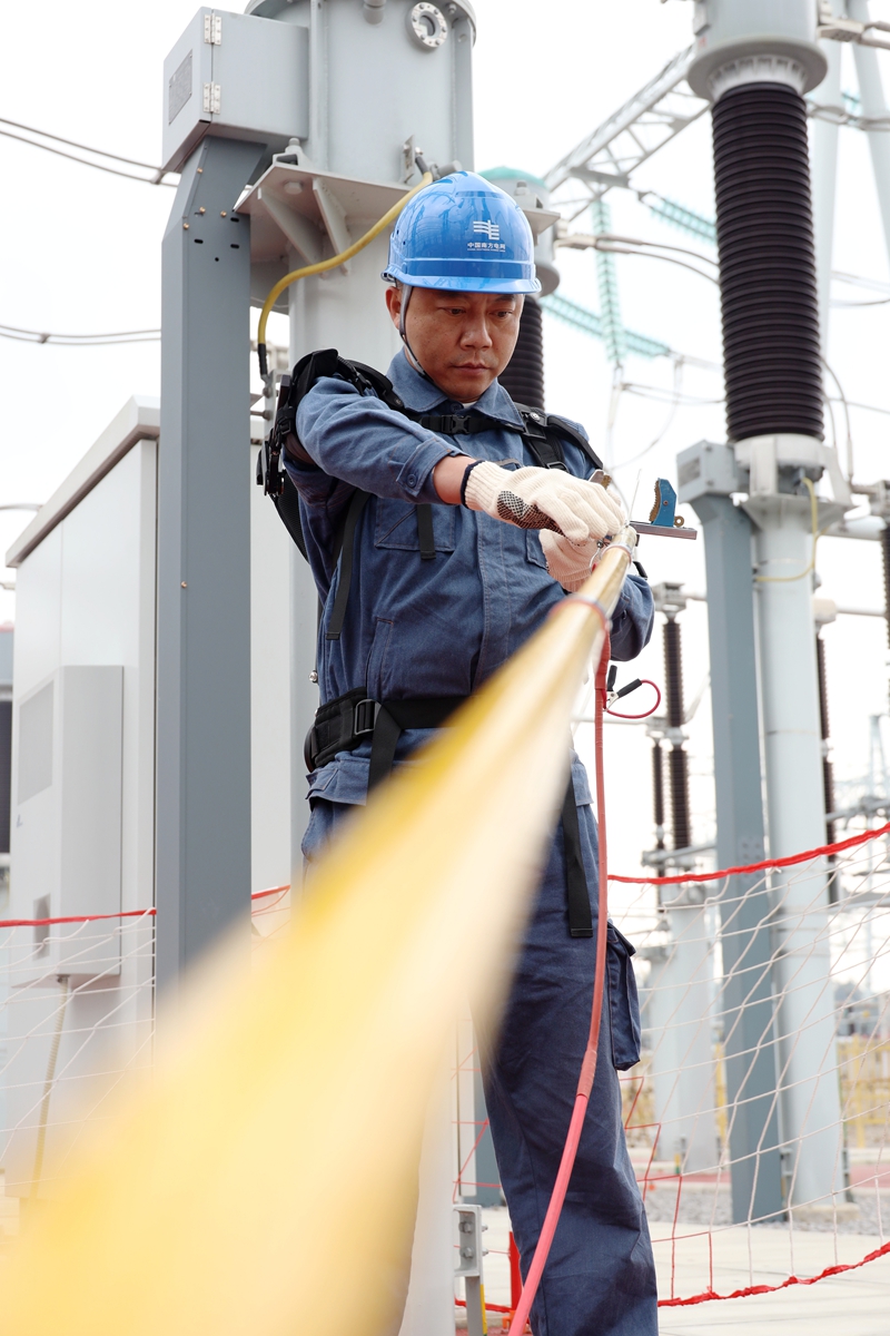 變電運維人員穿戴“省力機械手”對500 千伏變電設備進行巡檢。