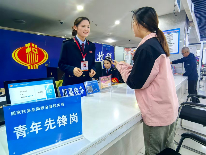 圖為稅務干部為納稅人辦結稅務事項并講解相關稅費優惠政策。童霖攝