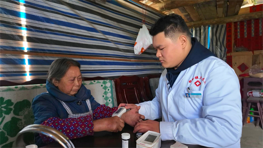 印江自治縣新寨鎮茶圓村村醫丁銘彥入戶為群眾開展健康檢查。