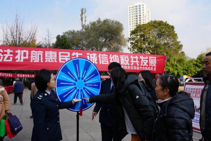 “普法講解員”在趣味游戲區與群眾互動。李琪攝