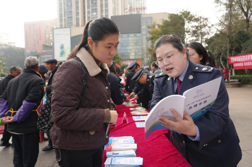 稅務干部在服務臺前為群眾面對面解答疑問。李琪攝