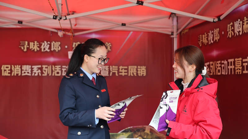 赫章縣2026年“尋味夜郎·樂購赫章”新春促消費系列活動中，國家稅務總局赫章縣稅務局深入活動同步跟進、主動靠前、精準發力開展稅收服務，圖為稅務干部向美食商戶貴州赫桃姑農產品開發有限公司參展銷售人員王藝霖了解經營情況，同時開展“點對點”答疑和“手把手”教學。（陳焰宏 攝）