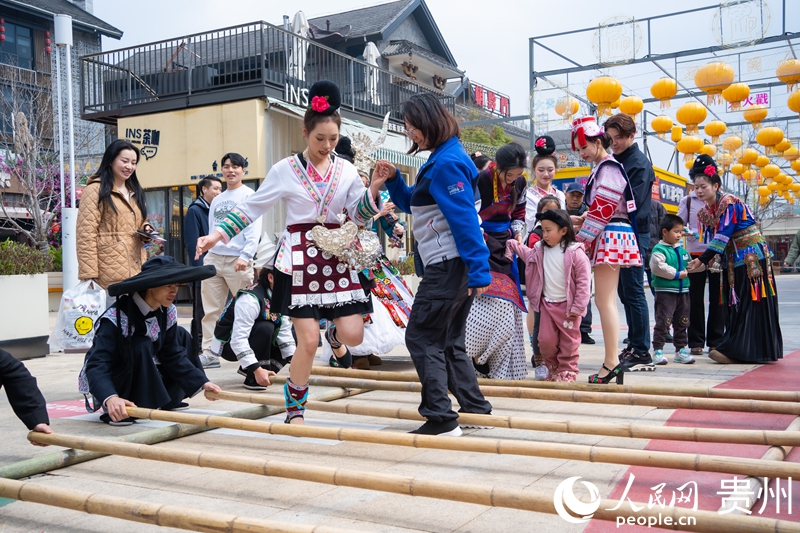 5多彩貴州城民族竹竿舞吸引客人參與體驗。人民網(wǎng) 陽茜 攝.jpg